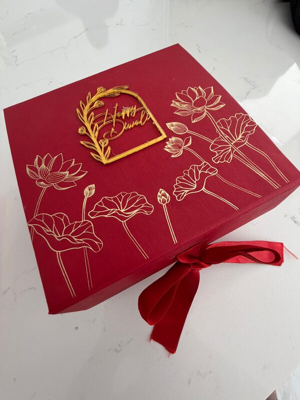 Red box with gold lotus print and Happy Diwali topper